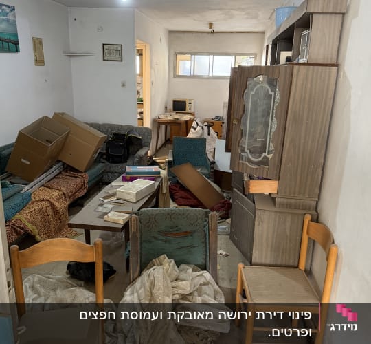 חדר מבולגן עם רהיטים וקרטונים, לפני פינוי